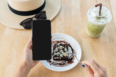 Midsection of person holding drink served on table