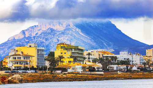 Panoramic view of buildings and mountains against sky