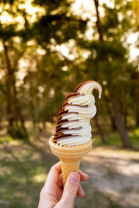 Female hand holding delicious american vanilla chocolate ice cream. tasty homemade icecream gelato