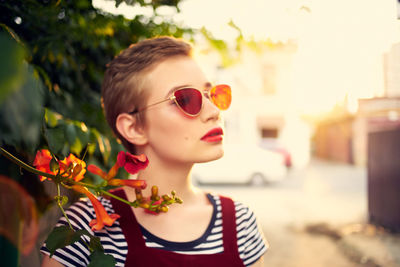 Close-up portrait of young woman wearing sunglasses