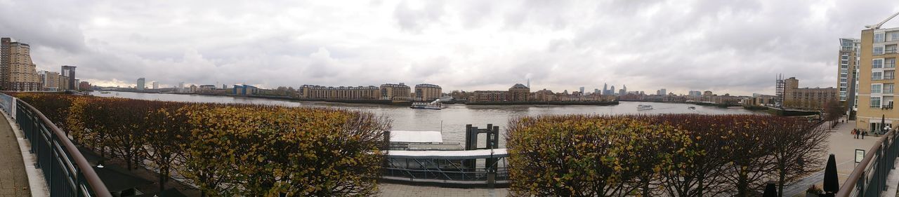 architecture, built structure, sky, building exterior, water, cloud - sky, river, cloudy, city, cloud, bridge - man made structure, railing, cityscape, connection, panoramic, day, transportation, plant, canal, outdoors