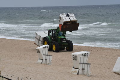 Deck chairs on beach against sky