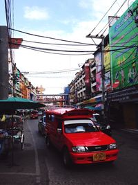 Cars on street against sky in city