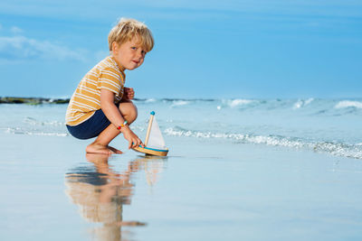 Side view of boy playing on beach