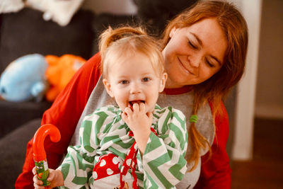 Portrait of smiling mother and daughter at home