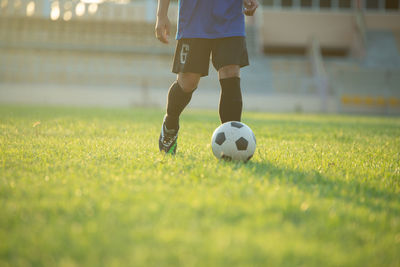 Low section of person playing soccer on field