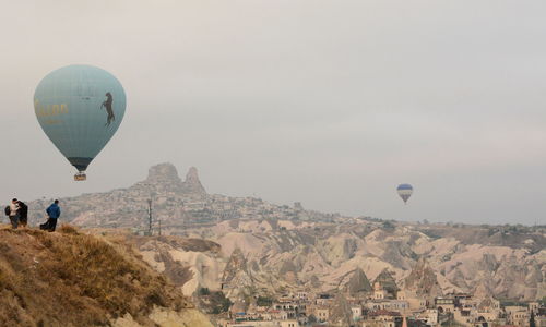Hot air balloon flying over landscape against sky
