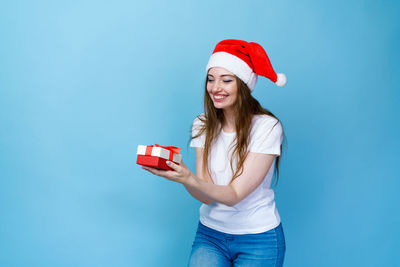 Beautiful young woman in hat against blue background