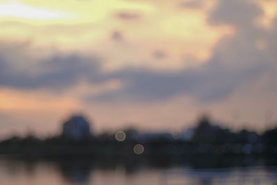 Defocused image of lake against sky during sunset