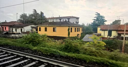 View of railroad tracks by buildings against sky