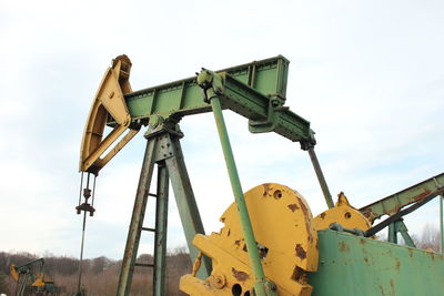 Drilling rig on field against sky