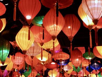 Traditional colorful paper lanterns hanging on dark ceiling