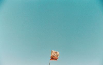 Low angle view of information sign against clear blue sky