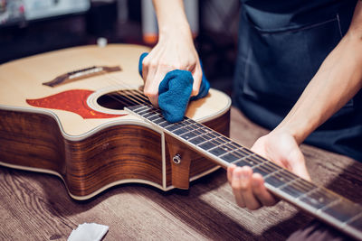 Midsection of man playing guitar