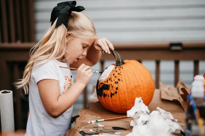 Rear view of woman holding pumpkin