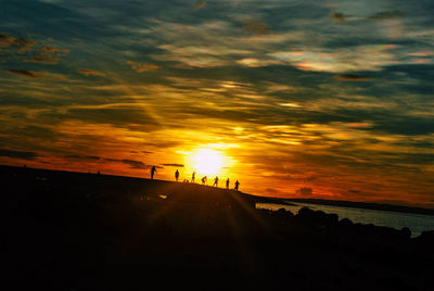 Silhouette landscape against sky during sunset