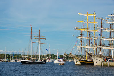 Sailboats moored on sea against sky