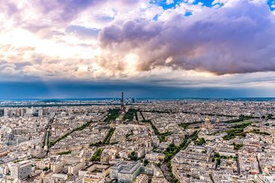 Aerial view of city against cloudy sky