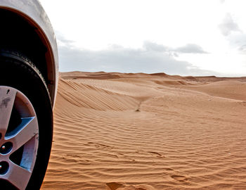 Close-up of car in desert against sky