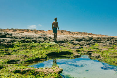 Young man exploring ocean bluffs during the summer in baja, mexico.