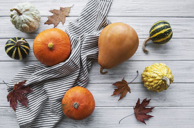 Autumn composition, cozy fall season, pumpkins and leaves on wooden background. 