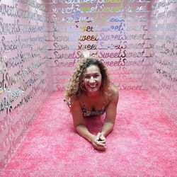 Portrait of smiling woman against wall with text