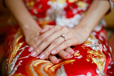 Midsection of bride sitting in traditional clothing during wedding ceremony