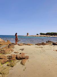Rear view of man looking at sea against clear sky