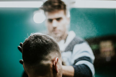 Barber setting hair of man in the barber shop