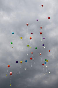 Low angle view of balloons flying against sky