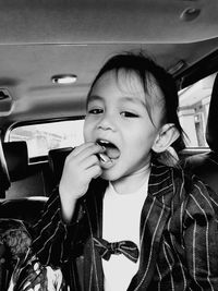 Portrait of cute girl sitting in car