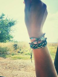 Young woman holding hands while standing on ground