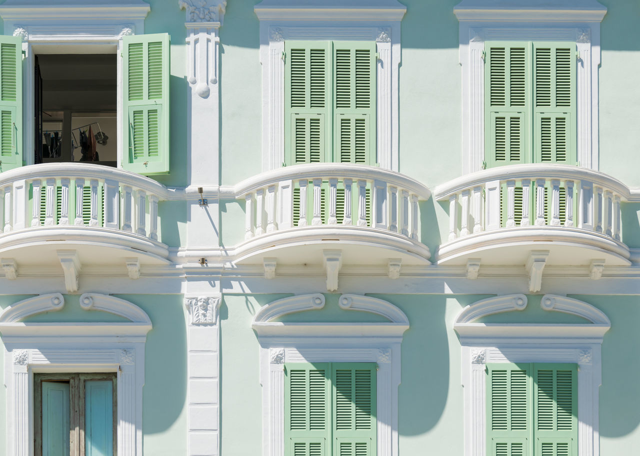 CLOSE-UP OF WHITE BUILDING WITH WINDOWS IN BACKGROUND