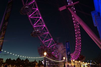 Low angle view of illuminated ferris wheel at night