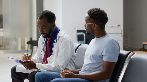 Side view of doctor examining patient in office