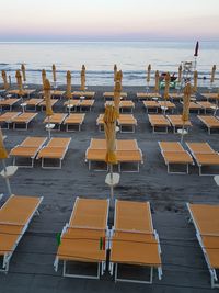 Chairs on beach against sky