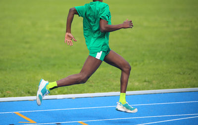 Low section of man running on track