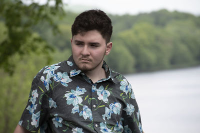 Portrait of young man standing against plants