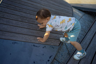 High angle view of boy standing on wood
