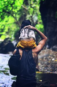 Woman holding stick on tree trunk