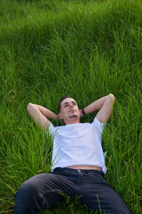 Portrait of young woman lying on grass