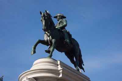 Low angle view of statue against blue sky