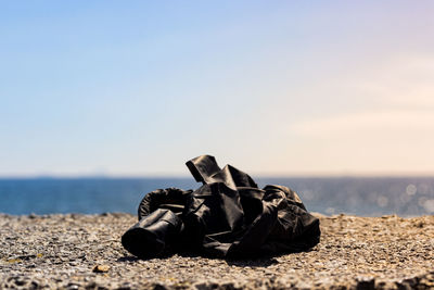 Shoes on beach against sky