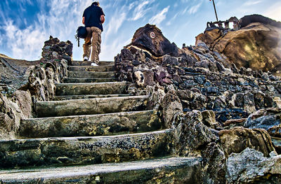 Low angle view of people on staircase against sky