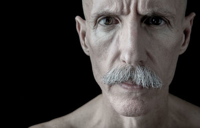 Portrait of mature man against black background