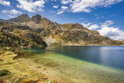 Scenic view of lake by mountain against sky