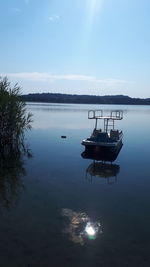 Sailboats moored in lake against sky