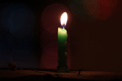 Close-up of illuminated candle in darkroom