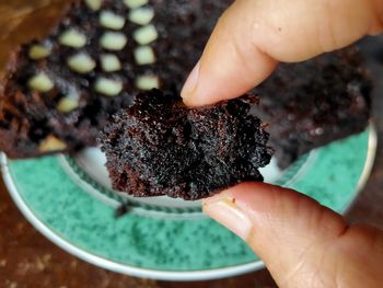 Close-up of hand holding fudge brownies