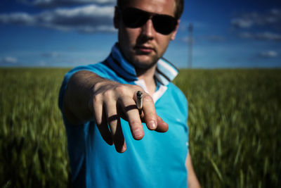 Portrait of young man with cigarette against landscape